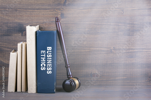 Business Ethics. Wooden gavel and books in background. Law and justice concept.