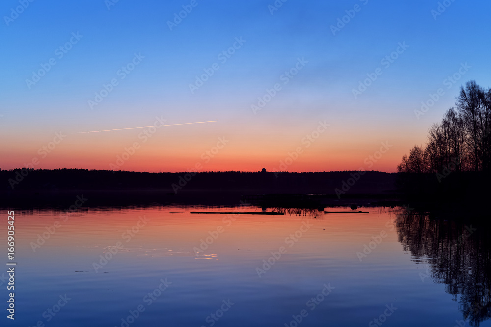 the evening lake water surface in the backdrop of the setting red sun blue background nature wallpaper