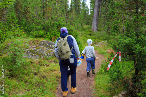 Family hiking in the taiga forest