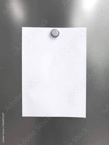 Blank white note paper with magnet clip on metal fridge / refrigerator door for reminder