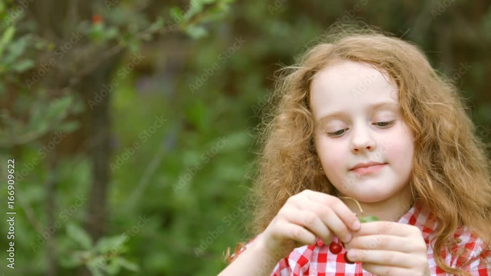 Little girl eating cherries in summer park. Little girl eating cherries in summer park.