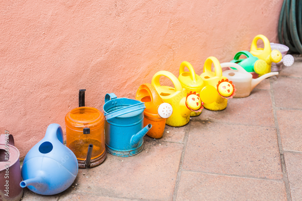 concept of gardening and hobby - A row of watering can concept of gardening and hobby - A row of watering can