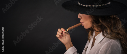 Portrait of sexy elegant lady woman with hat smoking cigar