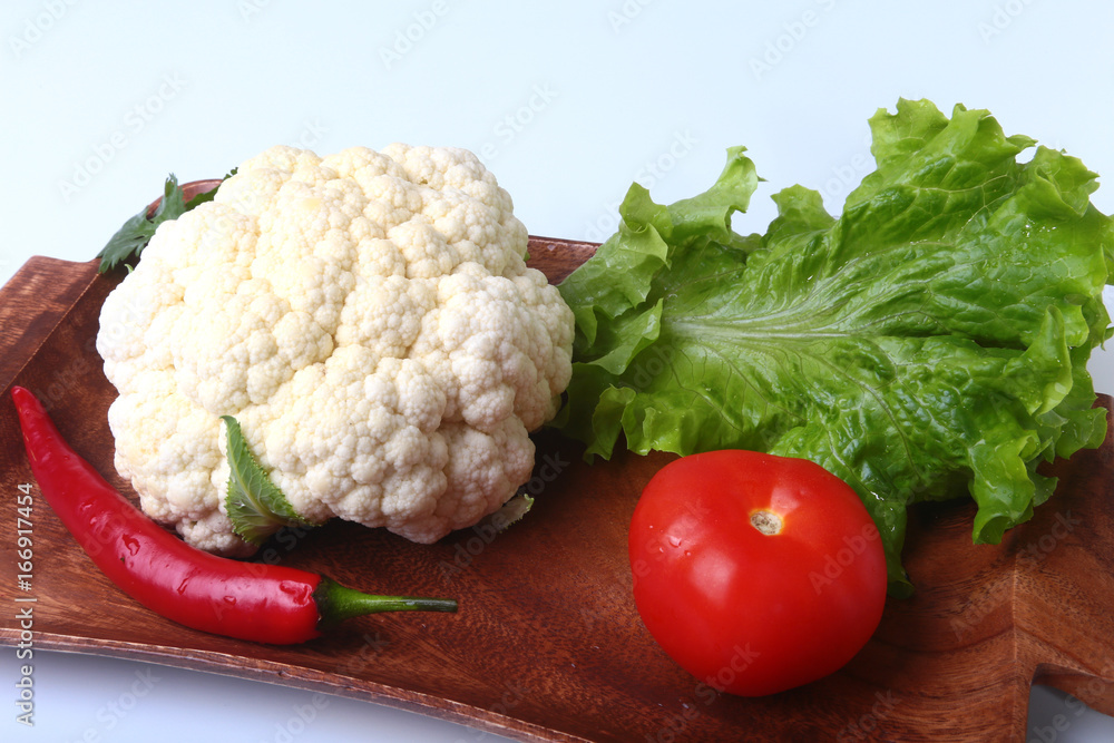 fresh cauliflower, tomato, salad leaves and other vegetables on wooden board. Ready for cooking. Vegetarian food. fresh cauliflower, tomato, salad leaves and other vegetables on wooden board. Ready for cooking. Vegetarian food.