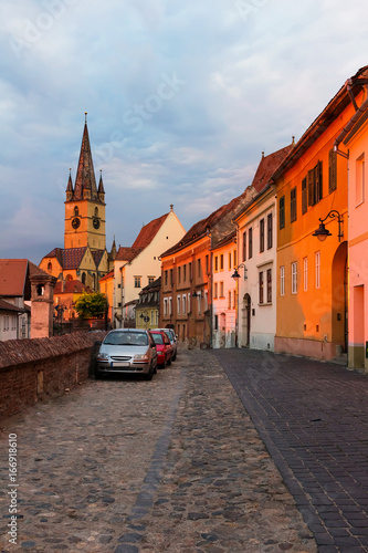 View on the ancient medieval street and Lutheran Cathedral in Sibiu city at sunset time