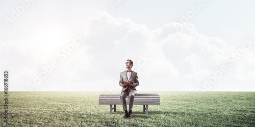 Young businessman or student studying the science in summer park