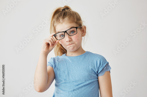 A shot of the little girl trying on glasses just for fun