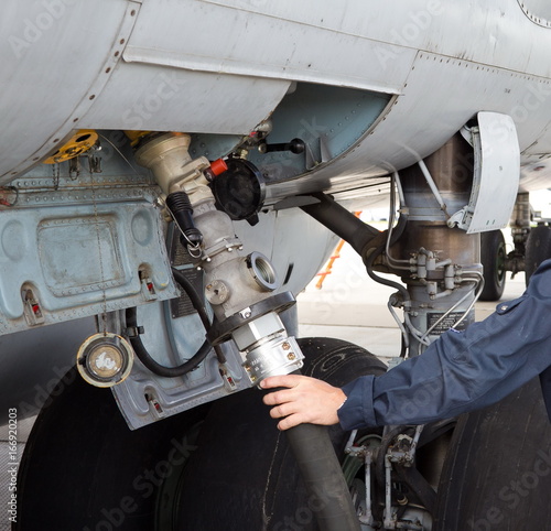 The process of refueling airplane in airport. Fuel hose is inserted
