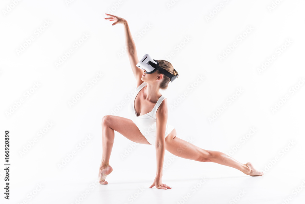 Somber youthful woman-gymnast exercising using video on goggles Somber youthful woman-gymnast exercising using video on goggles
