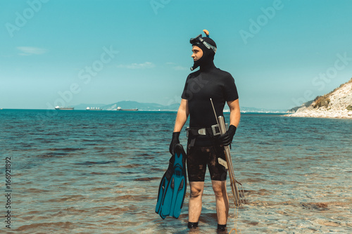 Underwater Hunter Man In Diving Suit With Equipment Goes To Sea In Summer Outdoors