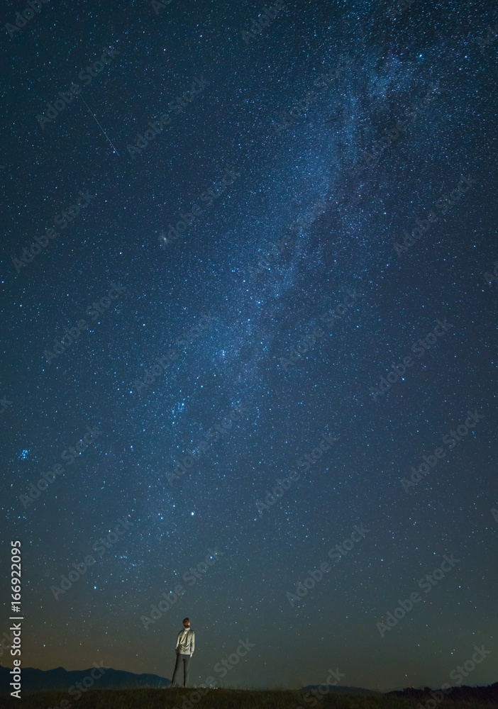 Fototapeta premium The man stand on the background of the starry sky. night time