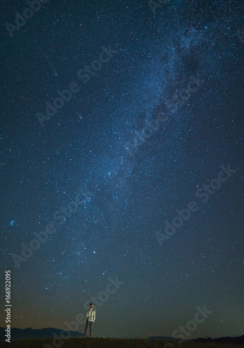 Fototapeta Naklejka Na Ścianę i Meble -  The man stand on the background of the starry sky. night time