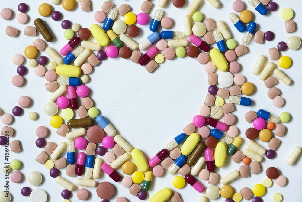 Heart of color pills on a white background