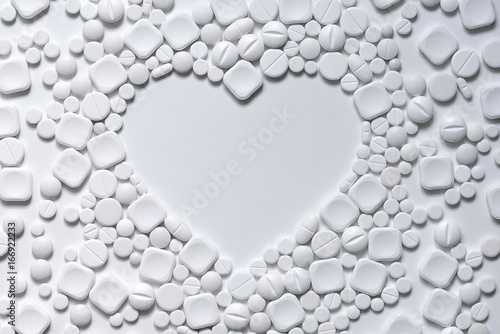 Heart of white pills on a white background