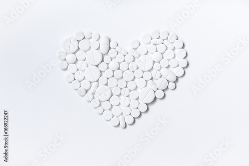 Heart of white pills on a white background
