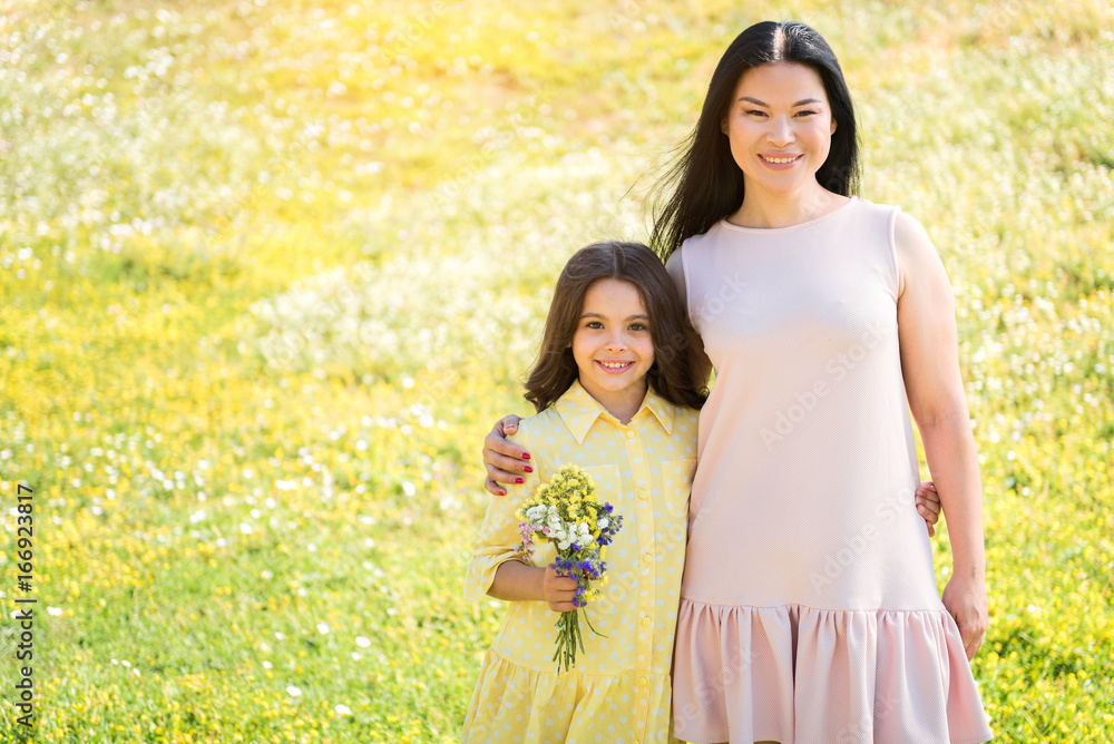 Friendly parent and child hugging on grassland Friendly parent and child hugging on grassland