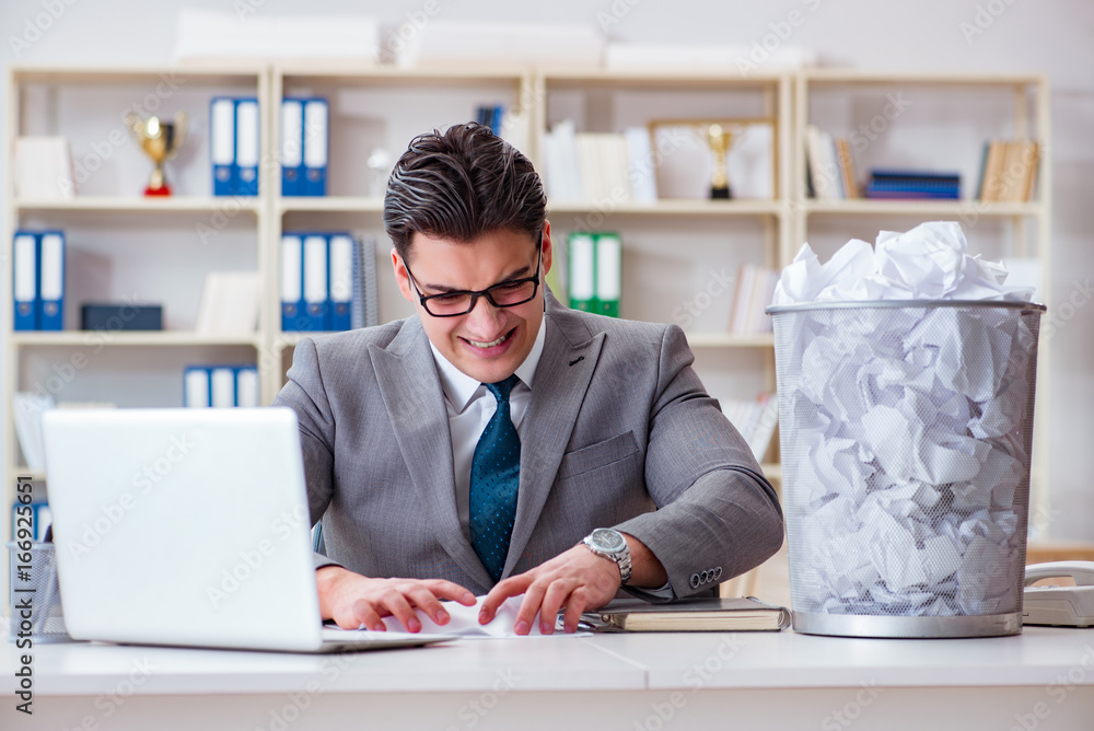 Businessman in paper recycling concept in office Businessman in paper recycling concept in office