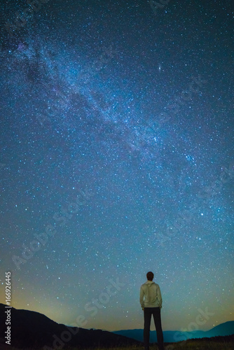 The man stand and look to the starry sky. night time