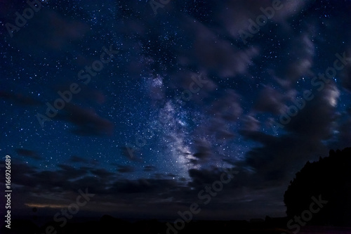 Wallpaper Mural Night sky full of stars glittering through parting clouds on a dark night in the wilderness Torontodigital.ca