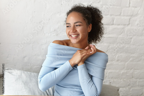 Foto Excited happy mixed race female with dark curly hair having eyes full of happine