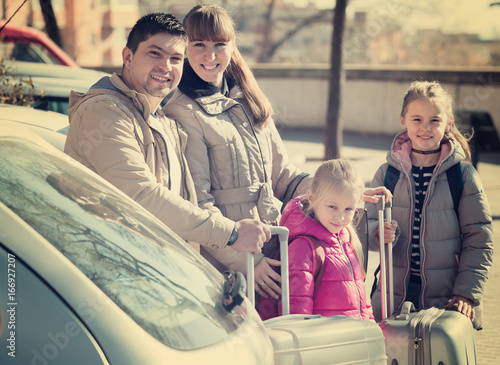 Happy family with luggage near car. © JackF