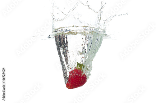Strawberry falling in the water with splash, isolated on a white background