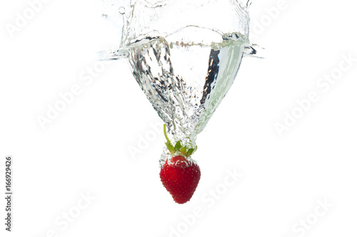 Strawberry falling in the water with splash, isolated on a white background