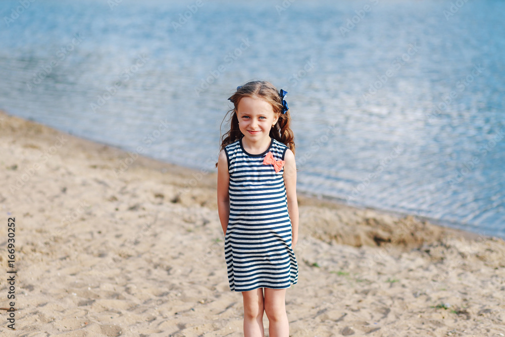 Portrait fashionable little girl beach vacation. Concept of a happy childhood. Portrait fashionable little girl beach vacation. Concept of a happy childhood.