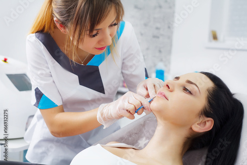 Woman having mesotherapy facial treatment at beauty salon. Close up