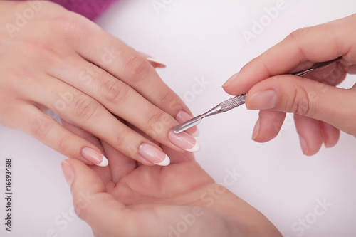 Nail Care. Closeup Of Beautiful Woman Hands Showing Perfect Nails Painted With Red Nail Polish On White Background. Female Hands Near Set Of Professional Manicure Tools. Beauty Care. High Resolution