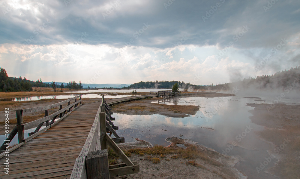 Boardwalk next to Tangled Creek and Black Warrior Springs leading into Hot Lake in the Lower Geyser Basin in Yellowstone National Park in Wyoming United States