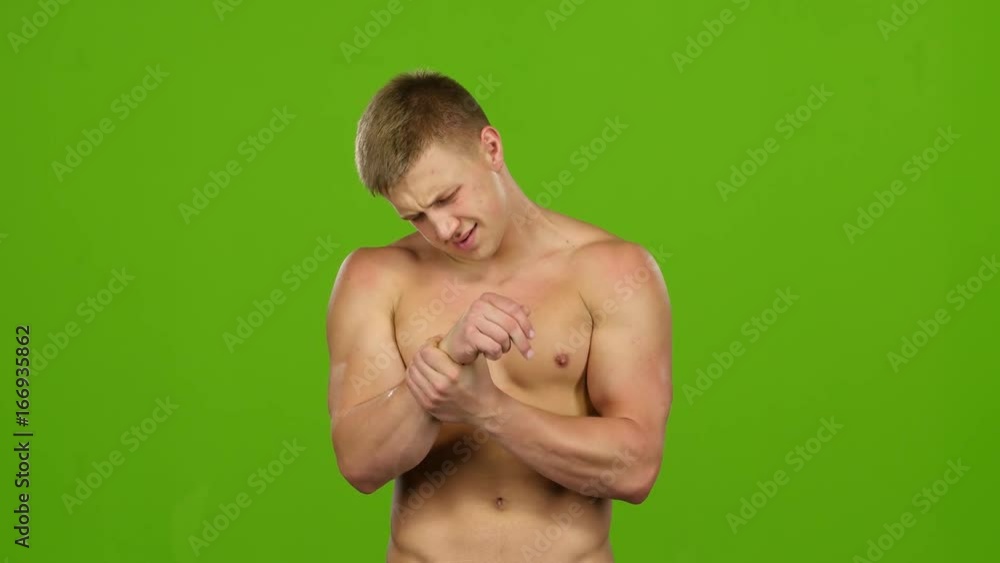 Man with naked torso suffers from pain in right hand Man with naked torso suffers from pain in right hand