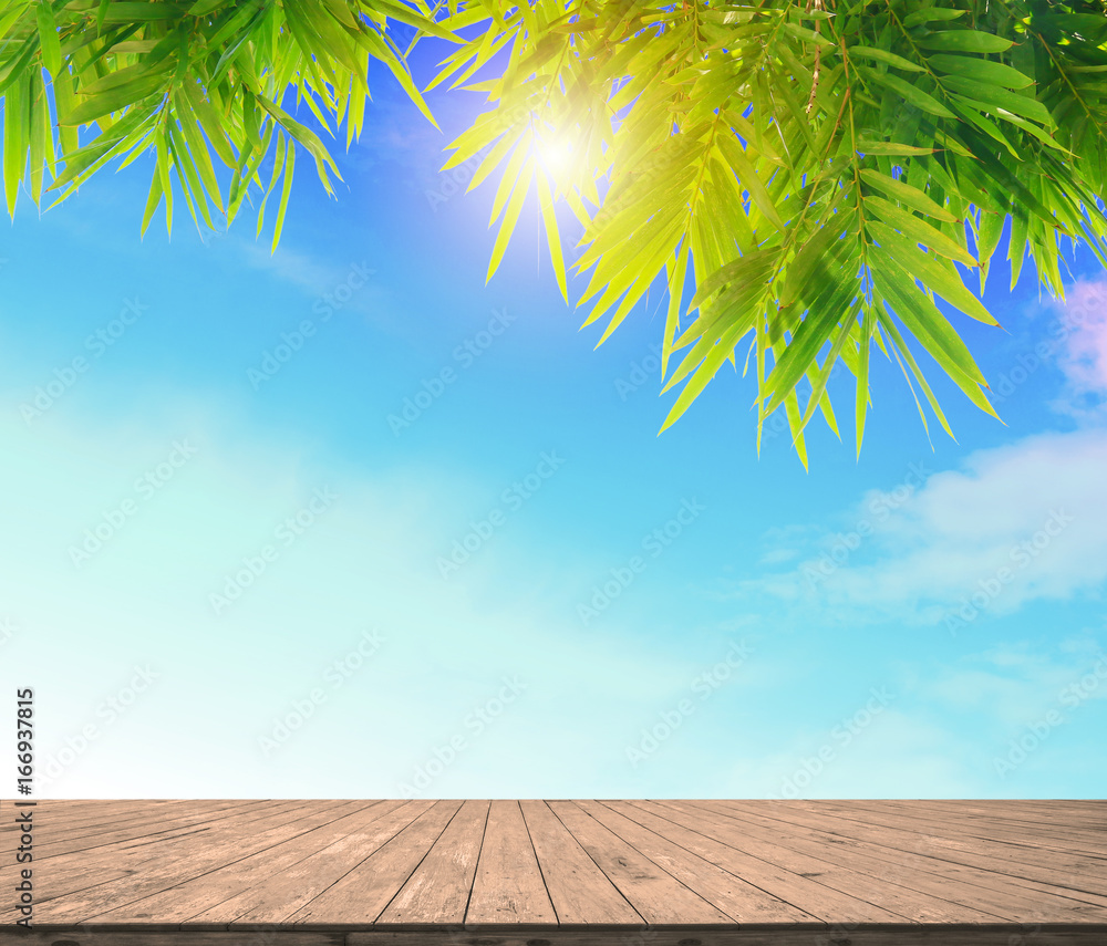 empty wood plank floor mock on the blule sky with green bamboo leaves and sun light for display or montage your work background empty wood plank floor mock on the blule sky with green bamboo leaves and sun light for display or montage your work background