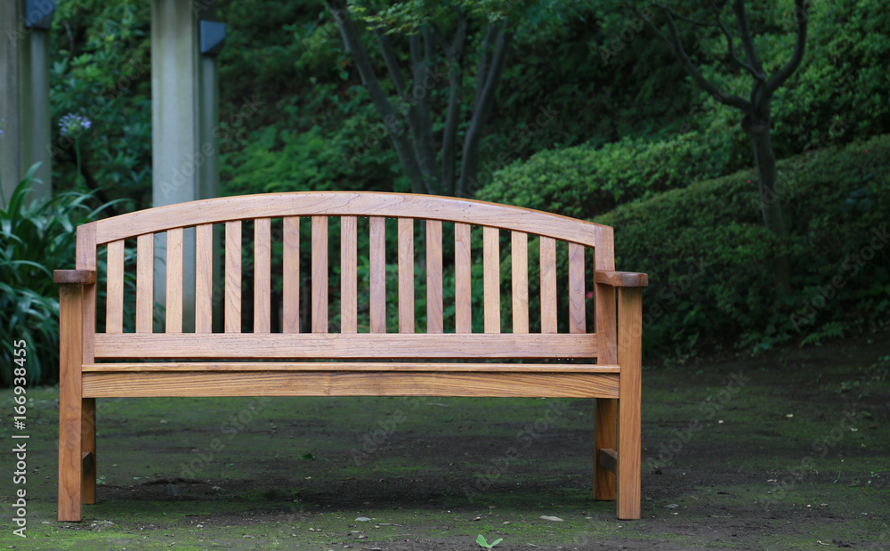 A wooden bench surrounded by park green A wooden bench surrounded by park green