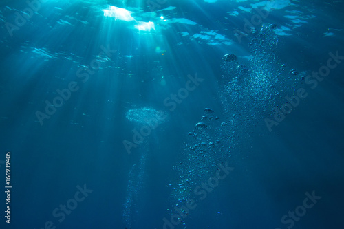 Abstract water background with rays of sun and air bubbles