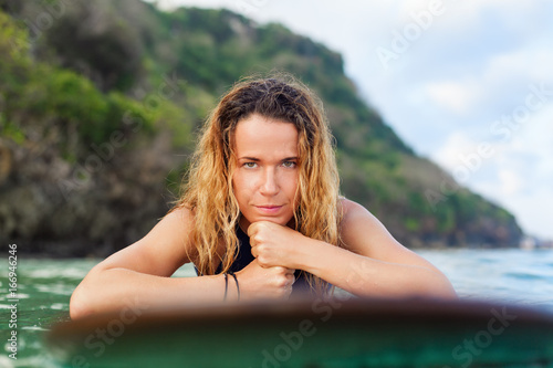 Photography Happy girl in bikini have fun before surfing Surfer lie on surf board, look at sunset sky