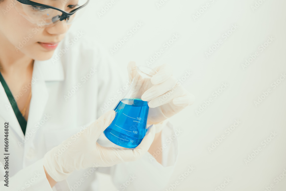 Fototapeta premium Young Asian scientist working in the lavatory with test tubes and other equipment to discover new drugs, products and methods of formulation