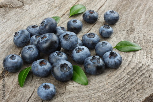 blueberries with green leaf on old wooden table background