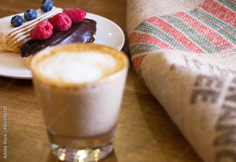 Cappuccino and cake with berries on table. Cappuccino and cake with berries on table.