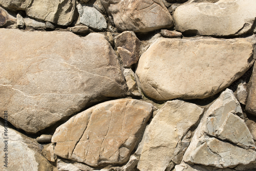 Fototapeta premium Big and brown stones on a wall