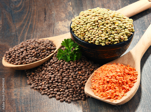 Composition with bowl of lentils on wooden table photo