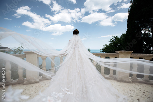 Obraz na płótnie Girl in white wedding dress with big waves on the sea background