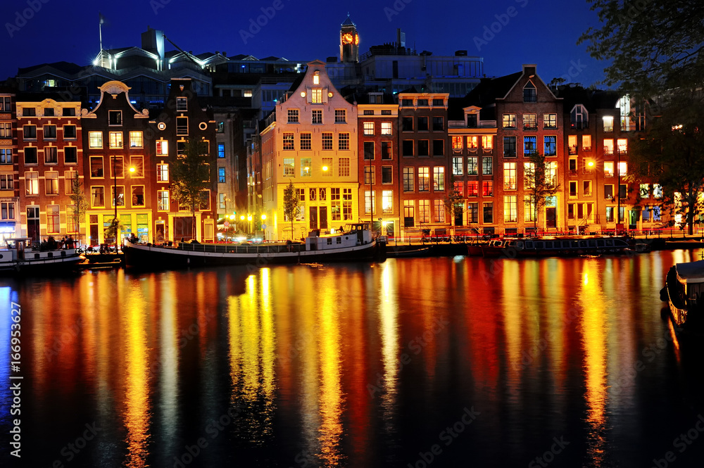 Scenic view of Amsterdam canal and buildings at night, Netherlands
