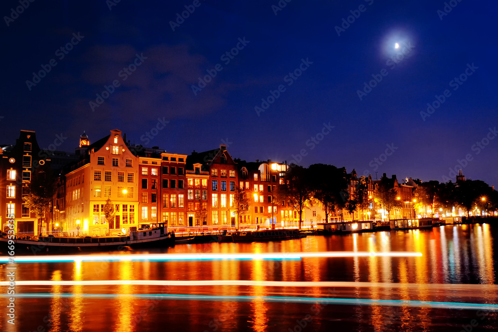 Scenic view of Amsterdam canal, buildings and lights at night, Netherlands
