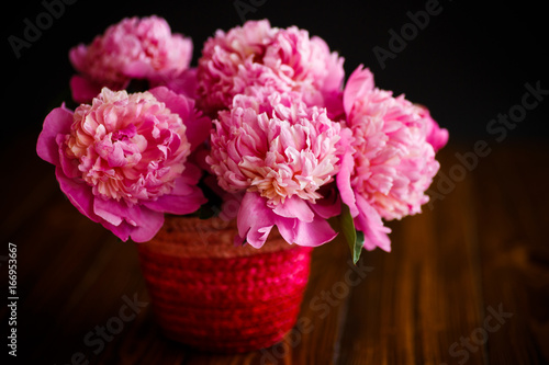 bouquet of pink peonies in a wicker vase