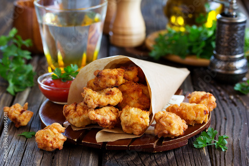 Fried nuggets of chicken breast with sauce.