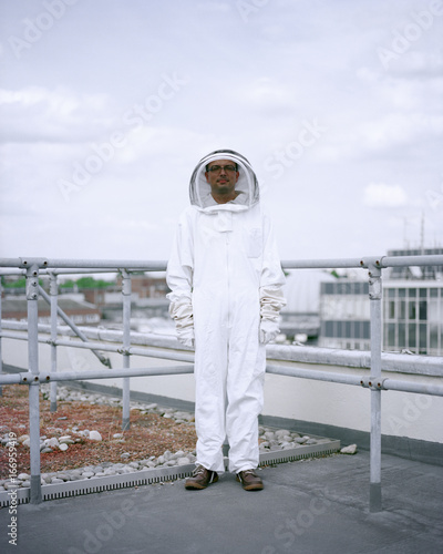 A bee Keeper stands among the rooftops of central London 