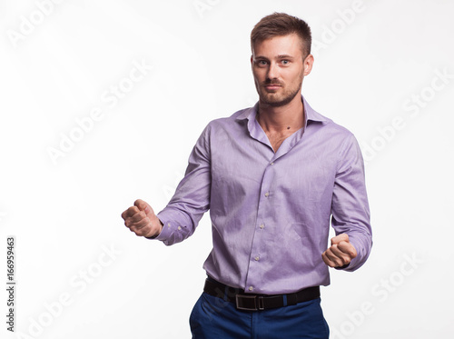 Young grumpy man portrait of a confident businessman showing by hands on a gray background. Ideal for banners, registration forms, presentation, landings, presenting concept.