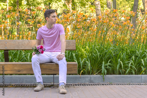 young men waiting date sitting on a bench with roses