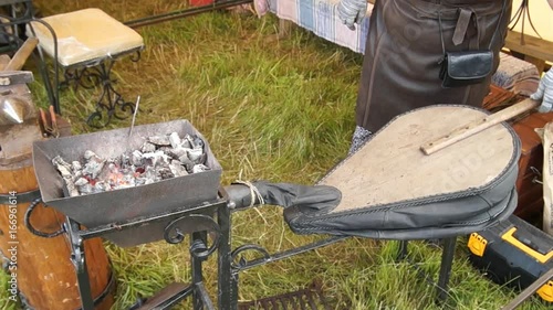 Blacksmith blows coals
